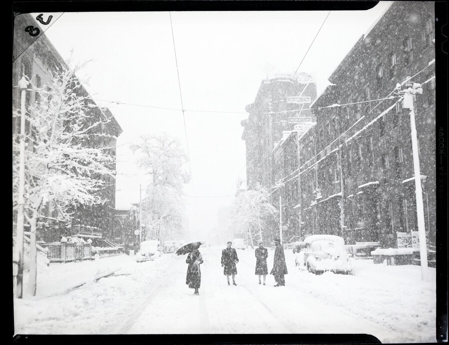 View of four people in the snow on Palm Sunday, looking south on the 700 block of Park Avenue in Baltimore, Maryland. The snowstorm brought nearly a foot of snow to Baltimore in 1942.