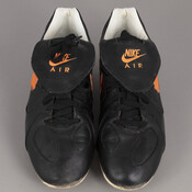 Black and orange Nike Air baseball cleats worn by Major League Baseball Hall-of-Famer and former shortstop for the Baltimore Orioles, Cal Ripken Jr (1960-). On the inside of the shoe the number 8 is drawn in marker, correlating to Ripken's number on the Orioles.