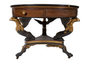 Federal style round table with gilt eagle heads and claw feet on casters. Table has round top with a brown velvet cover and a cross-banded rim inlaid with continuous serpentine brass ringing, and ebonized molded edge. Apron with gilt moulding at top, three drawers and three false drawer fronts. Drawers originally had round brass knobs…