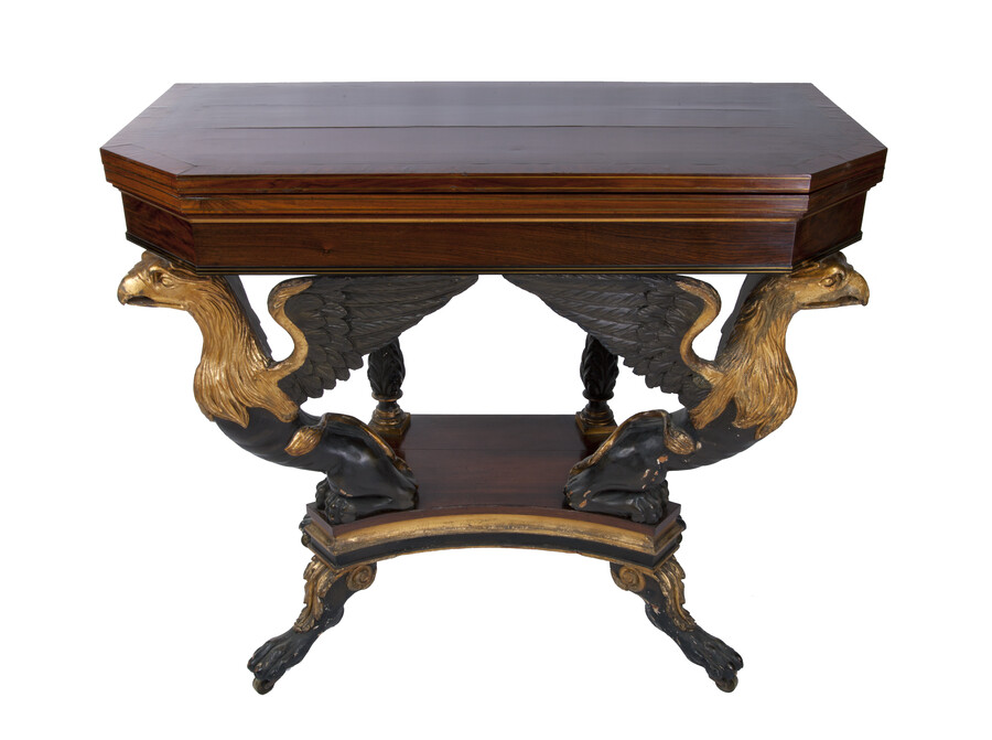 New York-made fold-out card table with rectangular pivoting hinged top and red velvet surface. Gilded and ebonzied legs in the shape of eagle heads with inlay detail. Table has chamfered front corners and sits on brass casters.
