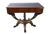 Low rectangular table with gilt eagle head supports, ebonized legs, carved acanthus leaf detail, and claw foot casters.