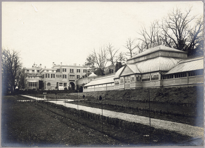 Rear exterior view of Evergreen House and greenhouse — circa 1910