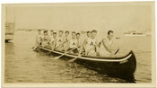 View of 12 men rowing a boat for the Arundel Boat Club at Ferry Bar in the Patapsco River at Light Street in Baltimore, Maryland.