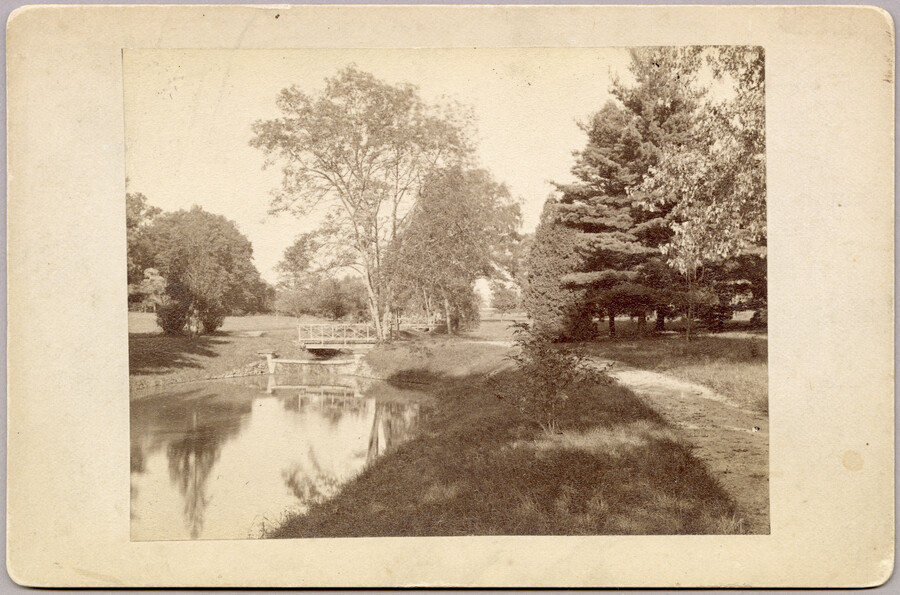 A pond and footbridge on the grounds of the original Guilford mansion, a home built by William McDonald after inheriting the land from his father General McDonald in 1850. Arunah S. Abell, founder of The Sun, purchased the property in 1872 and it remained in the Abell family until it was sold to the Guilford…