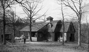 View of a horse, carriage, and two men standing in front of a stable on the Kedleston estate located in Ruxton, Maryland. Designed by John Appleton Wilson and his cousin William Thomas Wilson, this 18-acre estate was the country seat of Richard Curzon Hoffman (1839-1926), a Baltimore stock broker and railroad official.