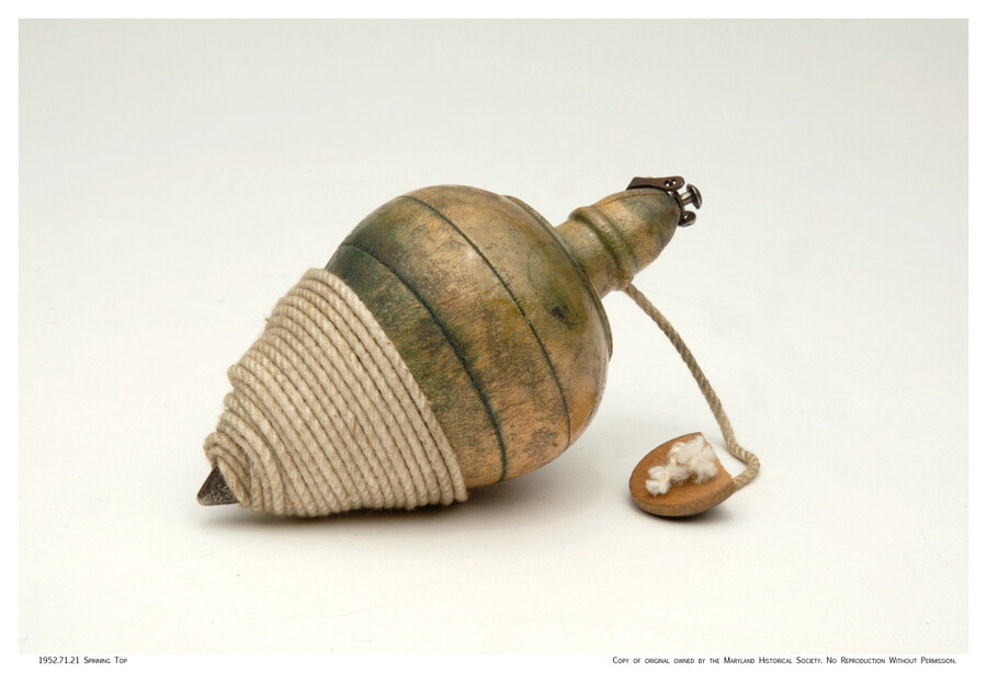 Wooden spinning top toy with twine wrapped around narrow base.