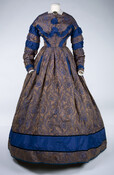 Gold and blue figured silk gown with floral patterned panels, full round skirt, and full-length ruched sleeves. Worn by a member of the Mackintosh family. The material was said to have been brought from China by by a family member who was a sea captain. There is a morning wrapper made of the same fabrics…