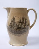 Creamware pitcher with bulbous form and black transfer printed designs on front and sides. Front bears the motto "SUCCESS TO THE INFANT NAVY OF AMERICA" inside a wreath. One side bears images of the shipbuilding process from tree to finished ship with words of poem beginning "Our Mountains are cover'd with Imperial Oak." The other…