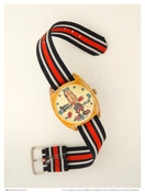 Wind-up wristwatch with image of Spiro T. Agnew (1918-1996). The full-length caricature-styled image of Agnew depicts him wearing red, white and blue striped pants and shoes, a blue bandoleer with white stars, and red-gloved hands form the hour and minute hands. The 12, 3, 6, and 9 numerals are in medium blue, and blue stars…