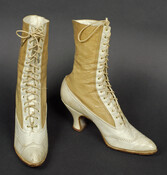 Women's two-toned white leather high-top lace-up boots with low heel.