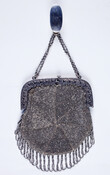 Steel bead frame purse decorated with a multi-lobed pattern radiating from center and a looped, beaded fringe hanging from bottom. Purse hangs from a double chain at the top that is attached to with a clip. Engraved with the intials "EPB" for Elizabeth Patterson Bonaparte (1785-1879), the clip would attach the purse to her waistband.…