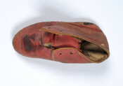 Red leather doll's shoe stamped with the phrase "Welcome Lafayette" and with his portrait on the toe box. The shoe was likely made as a commemorative souvenir of the Marquis de Lafayette's return visit to the United States in 1824. Gilbert du Motier (1757-1834), the Marquis de Lafayette, was a key figure during the American…