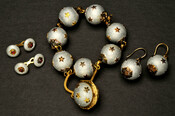Demi-parure or jewelry set belonging to Elizabeth Patterson Bonaparte (1785-1879) that is likely French in origin. The set is comprised of a bracelet, one pair of earrings, and dress links. Each piece is comprised of silver balls covered in attached golden stars. The links are set with rubies.