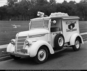 A Good Humor ice cream truck. The side reads "Ice Cream Good Humors" with a large graphic of a partially eaten ice cream bar. Signs on top read "A Nutritious Food" and "Good Humor Man," and the door reads "Buy Them Here." The truck is numbered 59.