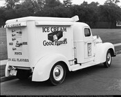 Rear view of a Good Humor ice cream truck. The side reads "Ice Cream Good Humors" with a large graphic of a partially eaten ice cream bar, and the rear reads "Ice Cream Sold Here It's Pure Cream Pints In All Flavors." An advertisement on the door reads "Special! Black Cherry Pints 35¢." The truck…