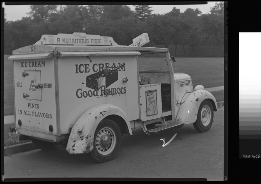 Rear view of a Good Humor ice cream truck. The top reads "Good Humor A Nutritious Food." The side reads "Ice Cream Good Humors" with a large graphic of a partially eaten ice cream bar. Signage on the rear reads "Ice Cream Sold Here It's Pure Cream Pints In All Flavors." An advertisement on the…