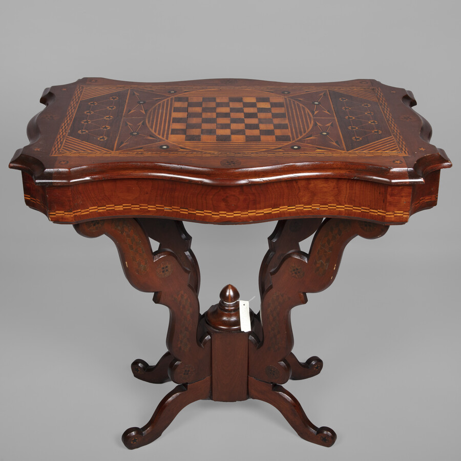 Wood, inlaid game table made by Henry Smith, Jr. (1853-1916), c. 1870-1875. Smith, Jr was born in Maryland and was the son of German immigrants. He attended public schools and the Maryland Institute (MICA) to study architecture. His father, Henry Smith, Sr. (1831-1890) was a carpenter and builder who established his building firm around 1862.…