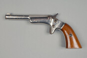 Wood-handled .22 caliber "tip-up" single shot pistol with serial number 7896.