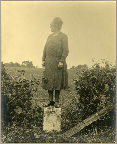 Woman standing atop Mason-Dixon line 15-mile crownstone — 1930-09