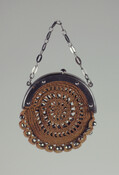 Circular crocheted brown silk change purse, closes with attached steel frame. Open work circular crochet design has faceted steel beads threaded into bottom border. Belonged to Mary Goulding (d. 1859).