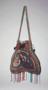 Beaded handbag with long handle of matching design and drawstring closure. Bottom edge embellished with beaded fobs. Decorated with multicolor seed beads in an abstract Art Nouveau style pattern. Lined with gray silk crepe.