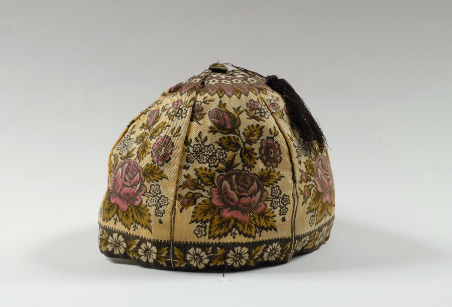 Cotton twill men's smoking cap with printed pink and green floral pattern. Cap is topped with a black silk fringe tassel. This cap was worn by Charles Elias Wethered (1807-1888), a Quaker and Baltimore merchant. He was the son of Lewin Wethered (1778-1863) and Elizabeth Ellicott (1787-1862). Beyond his occupation, he was a director of…