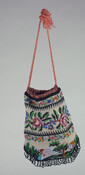 Loom-woven beaded purse with off-white background. Front and back are striped with multi-colored floral and green geometric leaf patterns. The bottom panel features a pastoral setting with a house, foliage, and a girl in a blue dress. Green beaded looped fringe embellishes bottom edge. Lined with coral silk crepe. Handle is twisted coral cord drawstring…
