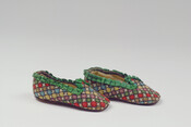 Pair of infant's wool polychrome needlepoint slippers with cross design and green ribbon trim. The shoes are lined with linen and have suede soles. Possibly belonged to Frederick William Brune (1813-1878).