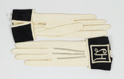 White, cuff-length kid leather gloves, with black cotton thread detailing on forehand. Turned down black satin grosgrain cuffs embroidered with initials "L.H." in white thread. One snap closure at each wrist. Gloves belonged to Miss Laura Hampson (b.1895) of Baltimore, Maryland.
