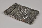 Silver card case with repousse design of a gothic building surrounded by trees above a floral design. Engraved with the name, "A.E. Morris."