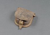 Black leather cap pouch, larger flap attached with brass stud at the bottom, smaller inner flap within, two belt loops on the backside. This pattern was used during the Civil War (1861-1865). It held the brass percussion caps that were used as the ignition sources for Springfield and Enfield rifles and used by both Union…