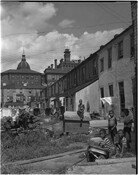 View of children playing behind a block of row homes in a neighborhood in East Baltimore, Maryland. This image was from a feature entitled "My Fate," which included multiple photographs by Robert Kniesche.