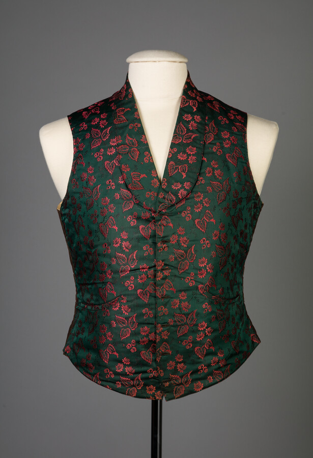 Dark green silk taffeta vest with red floral embroidery. Made by Annie M. Maguire for her husband. From the provenance, "She was a seamstress and made vests for Senators and Congressmen of Washington. She created special works for one of the best tailors in Baltimore, who had a shop on Lombard St."