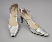 Pair of metallic silver leather heels with pointed toe and ankle clasp. Worn by donor when performing as Mother Helena, the Queen of Gospel, a Baltimore-area drag queen.
