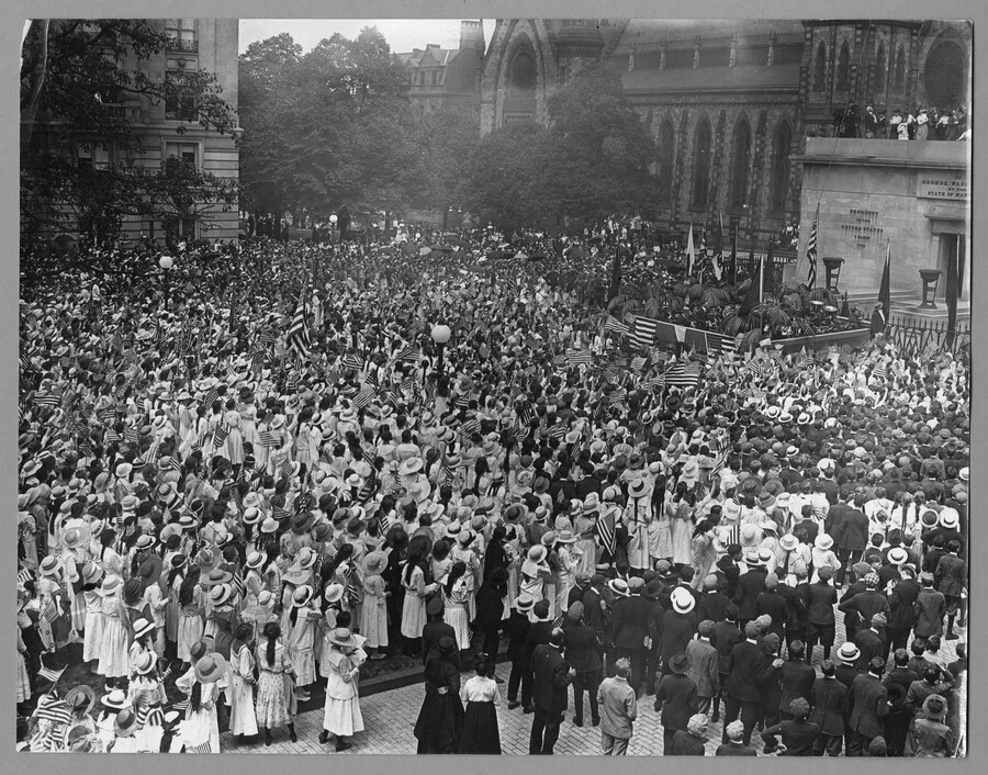 A large crowd gathered in Mount Vernon Place, Baltimore, Maryland, to welcome the arrival of the Marshal of France, Joseph Jacques Césaire Joffre, and the French Mission. The base of the Washington Monument can be seen on the right and many spectators hold American flags. Joffre visited the city as part of a French delegation…