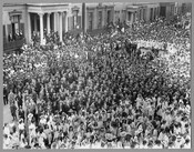 A crowd at Mount Vernon Place in Baltimore, Maryland, to celebrate the arrival of the Marshal of France, Joseph Jacques Césaire Joffre, and the French Mission. Women wear white dresses, while the men are in black suits with straw hats. Joffre visited the city as part of a French delegation touring the country after the…