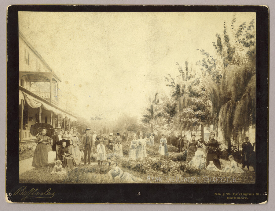 Approximately 30 adults and children in a garden at the Tolchester Beach Amusement Park in Tolchester, Maryland. The Tolchester hotel stands on the left of the garden. The Kent County park consisted of a bathing beach, amusement park, racetrack, and hotel, and operated from 1877 to 1962. It was a popular vacation destination for Baltimoreans…