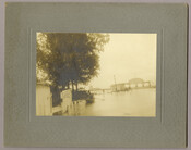 Approximately five figures during a flood at the Tolchester Beach Amusement Park in Tolchester, Maryland. The back of the park's entrance archway and its pier on the Chesapeake Bay can be seen in the background. This Kent County park consisted of a bathing beach, amusement park, racetrack, and hotel, and was in operation from 1877…