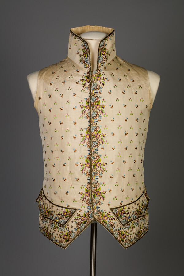 Ivory silk faille waistcoat with floral embroidery worn by William Pinkney in 1807. It features a high collar, cut-away fronts, and a cotton back.