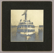 A front view of the "Louise," a sidewheel passenger steamship, at the Light Street pier in Baltimore, Maryland. Passengers are gathered on the decks of the ship. Owned by the Tolchester Steamboat Company, the "Louise" was one of the most popular excursion steamers on the Chesapeake Bay and could hold 2,500 people. The company ran…