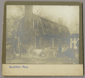 Side view of a small brick structure with a gambrel roof in Chestertown, Maryland. A figure stands at the door. It is possible that this is the Bedingfield Hands office, which was part of the property of the Bedingfield Hands house located on Queen Street in Chestertown.