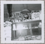 Interior view of a general store run by Mary Messick in Chesterville, Maryland. A person, possibly Messick, can be seen behind a case containing candy. Before serving as a store, the building was an inn known as the Chesterville Hotel.
