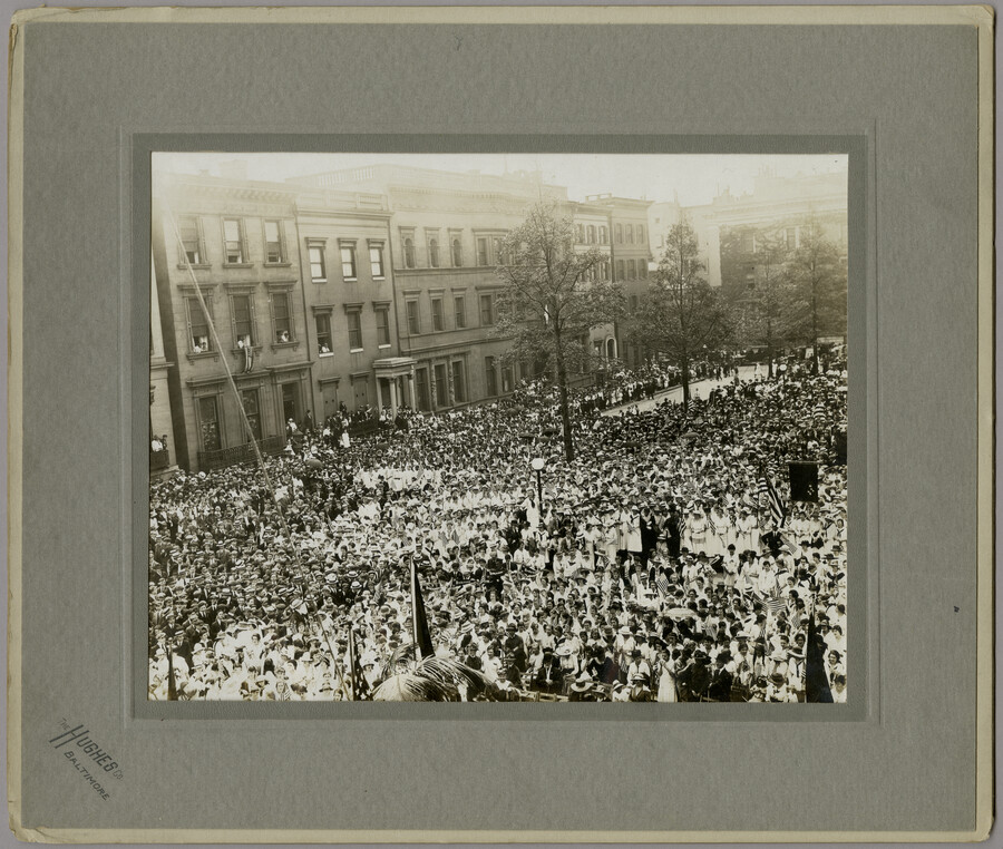 A large crowd of people holding American flags gathered at Mount Vernon Place in Baltimore, Maryland, to celebrate the arrival of the Marshal of France, Joseph Jacques Césaire Joffre, and the French Mission. Joffre visited the city as part of a French delegation touring the country after the United States entered World War I.