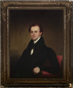 Half-length portrait shows George Steuart (1803-1850) as young man with red-brown hair, gazing directly at viewer. He wears black coat and collared jacket, and white high-collared shirt and stock. He is seated in red-upholstered armchair. George was the son of William (1760-1846) and Mary Scott Steuart (1775- ). In 1831, he married Sophia Rieman Steuart…