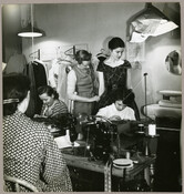 Undated photograph of American fashion designer Claire McCardell fitting a dress to a model.