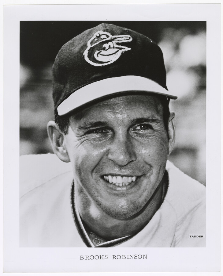Portrait of Brooks Calbert Robinson Jr. (1937-2023), third baseman for the Baltimore Orioles from 1955 to 1977, taken by team photographer Morton Tadder (1928-2020). He is pictured wearing an Orioles baseball cap. An 18-time All-Star and winner of 16 consecutive Gold Glove Awards, Robinson played his entire career for the Orioles, helping the team to…