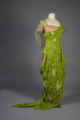 Silk brocade evening dress worn by Laura Patterson Swan Robeson (1881–1973). Laura Patterson Swan Robeson purchased this Cauët Sœurs gown on the Rue de la Paix in Paris, a boulevard renowned for the numerous couture houses based there. This gown’s asymmetrical drapery billows at the hips while tapering tightly down to the hem, creating a…