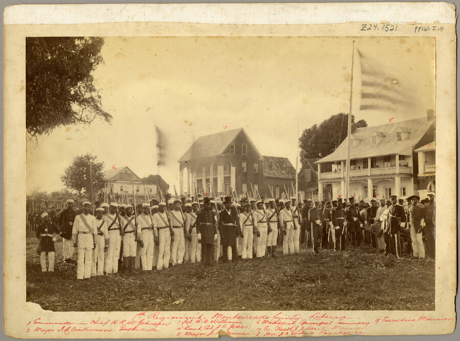 The First Regiment of Montserrado County, Liberia. Pictured at center are Commander-in-Chief Hilary Richard Wright Johnson (1837–1901) in top hat, with Major Dickinson to his left. Pictured behind the regiment are buildings identified as (from left): the Methodist Episcopal Seminary, ex-President Roberts' Mansion, the Honorable Wiles's residence, and the Executive Mansion.