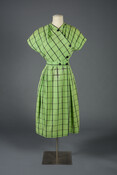 Short sleeved green dress with gray and black plaid pattern and matching belt.