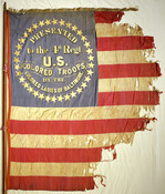 A 4th regiment United States Colored Troops Civil War flag. In August of 1863, the “Colored Ladies of Baltimore” presented this hand-painted, hand-sewn silk flag to the Fourth Regiment of United States Colored Troops. It is one of only twenty-five U.S.C.T. flags known to survive today The silk flag was carried in the 1864 Battle…